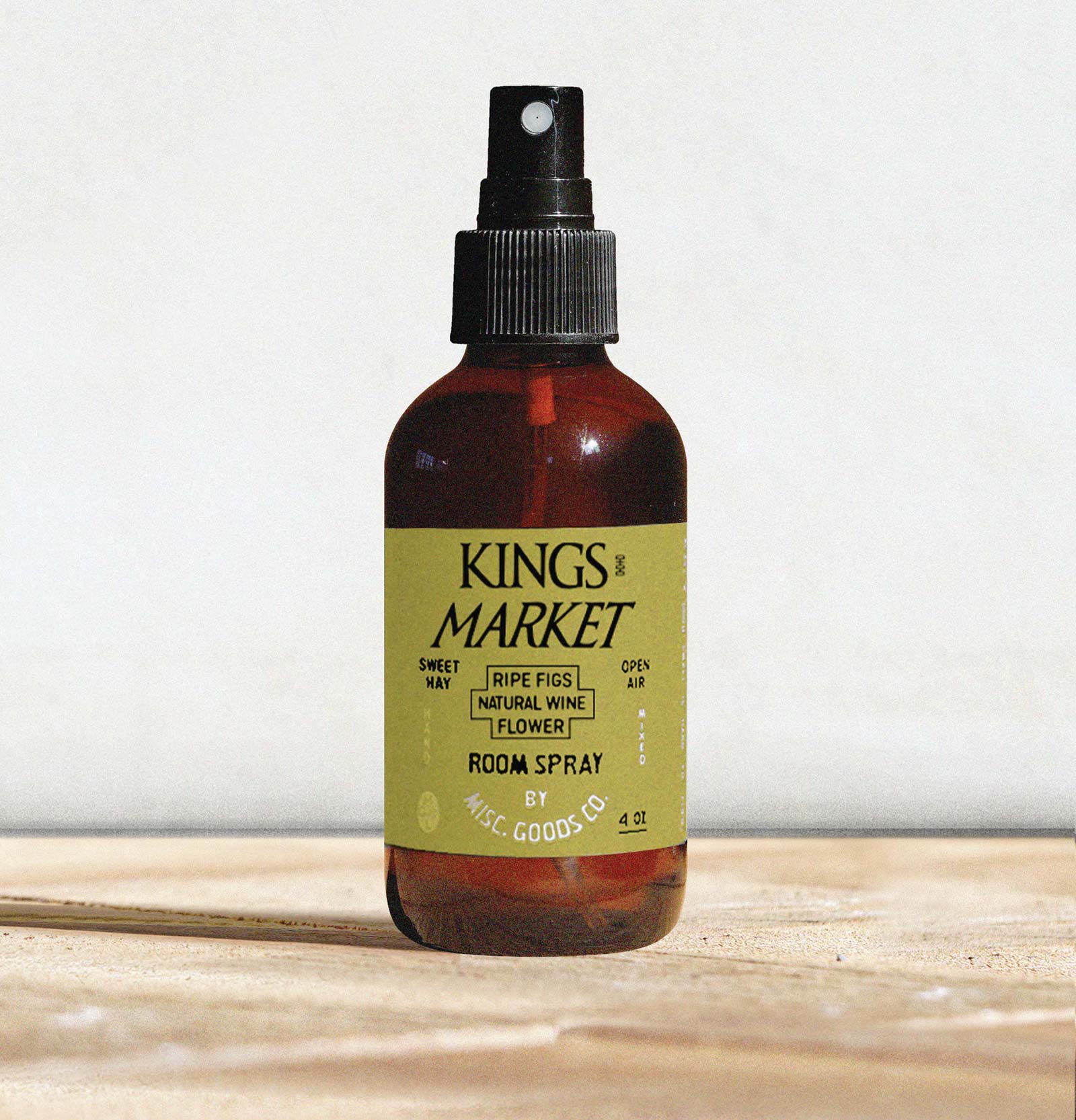 Bottle of Kings Market room spray on a wooden surface with a white background