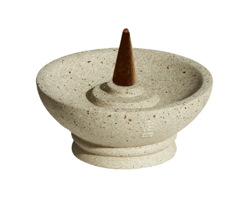 Decorative stone incense burner with a cone incense stick on a white background