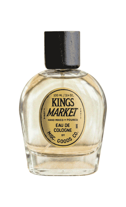 Clear glass bottle of Kings Market cologne with a black cap on a white background