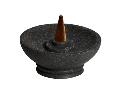 Black stone incense burner with a single incense cone on a white background