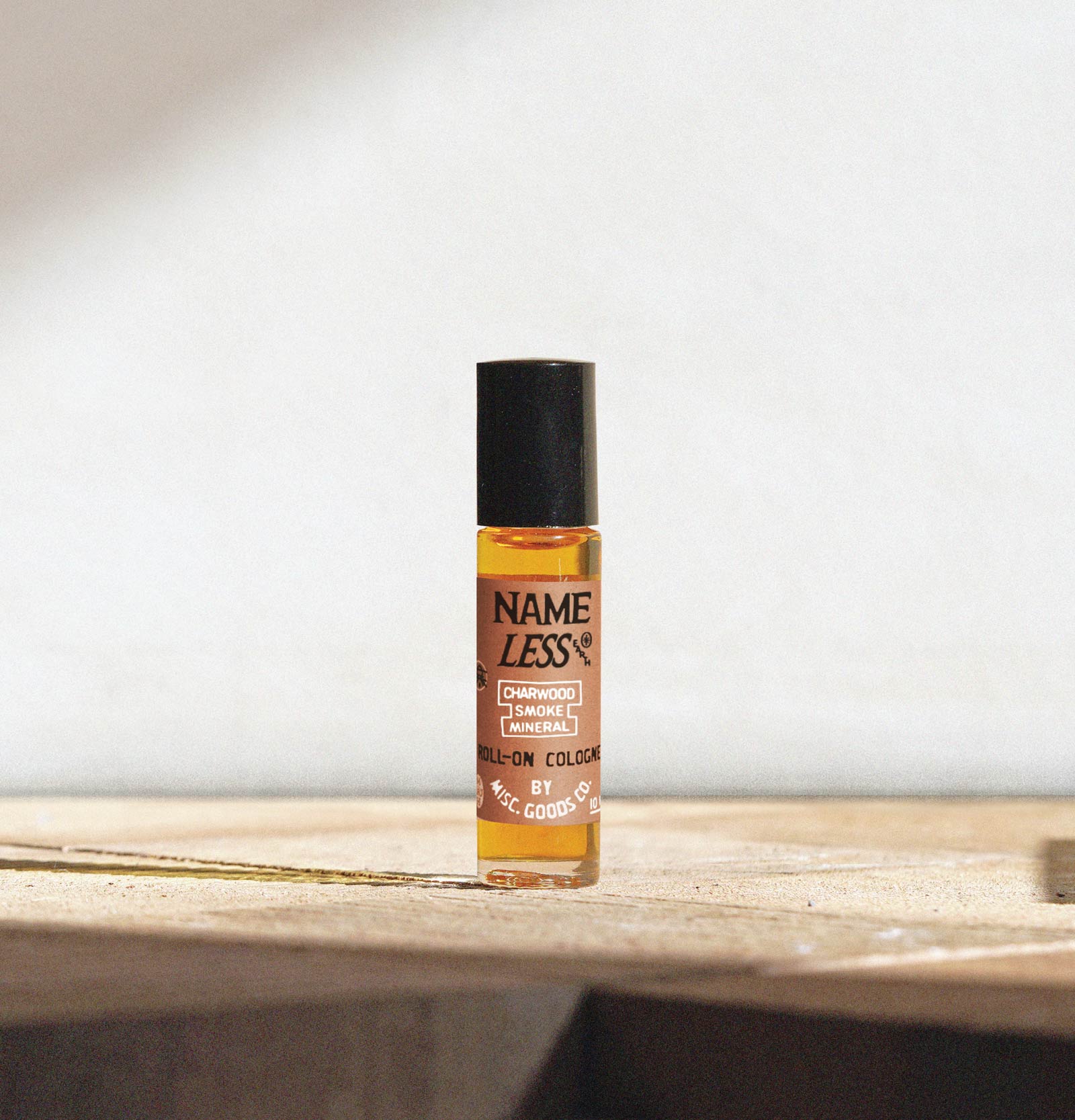 Nameless cologne bottle on a wooden surface with a white background