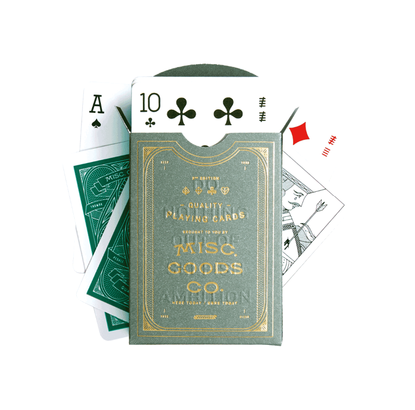 Playing cards with a green and gold packaging label, featuring the Misc. Goods Co. branding.