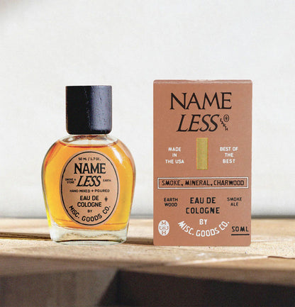 Name Less cologne bottle and packaging on a wooden surface with a neutral background