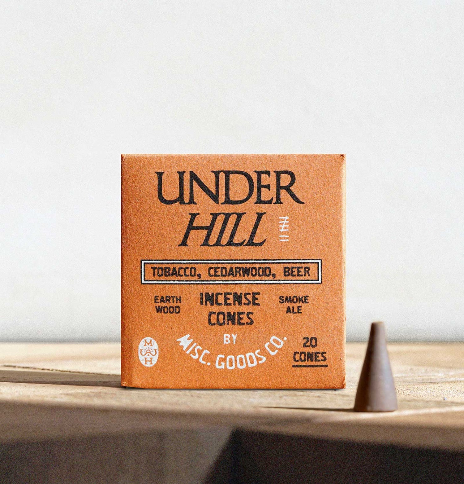 Box of Under Hill incense cones on a wooden surface with a white background